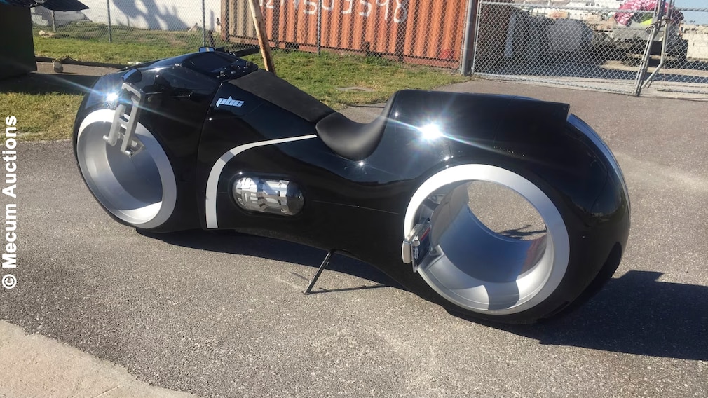 Schwarzes Motorrad im Tron-Lightcycle-Look steht im Freien.