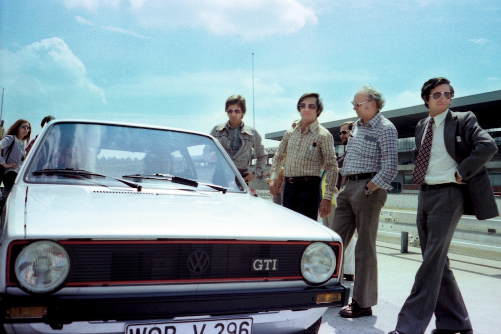 Historisches Farbfoto mit mehreren Männern an einem VW Golf Mk1 GTI