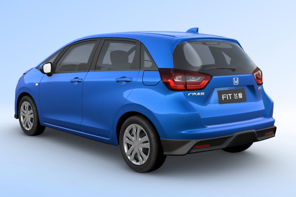 Blauer Honda Fit steht schräg von hinten vor neutralem Studiohintergrund.