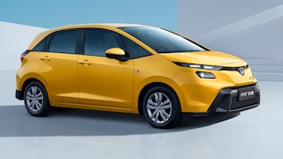 Gelber Honda Fit steht schräg von vorn in minimalistischer Studioarchitektur.