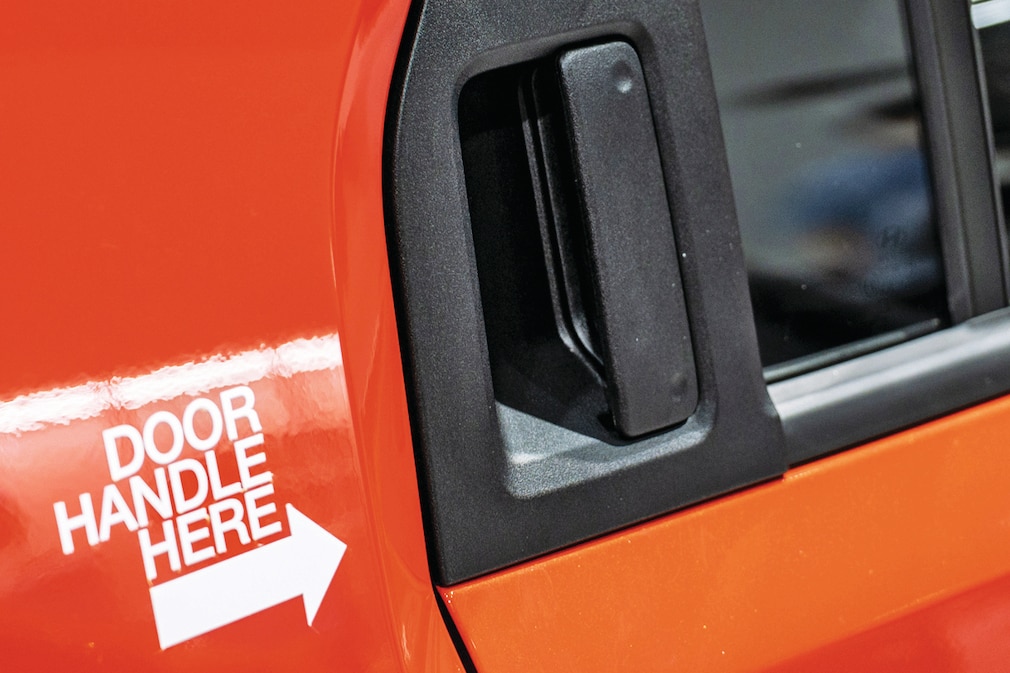 Hinterer Türgriff des Hyundai Casper, Aufkleber daneben mit Pfeil: "Door Handle Here"