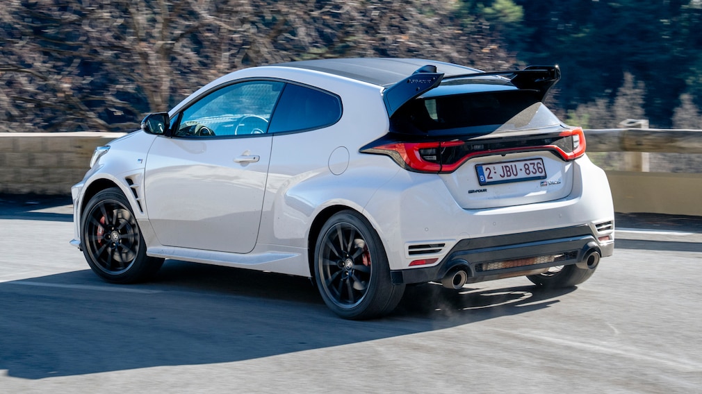 Toyota GR Yaris fährt schräg von hinten über eine kurvige Straße.