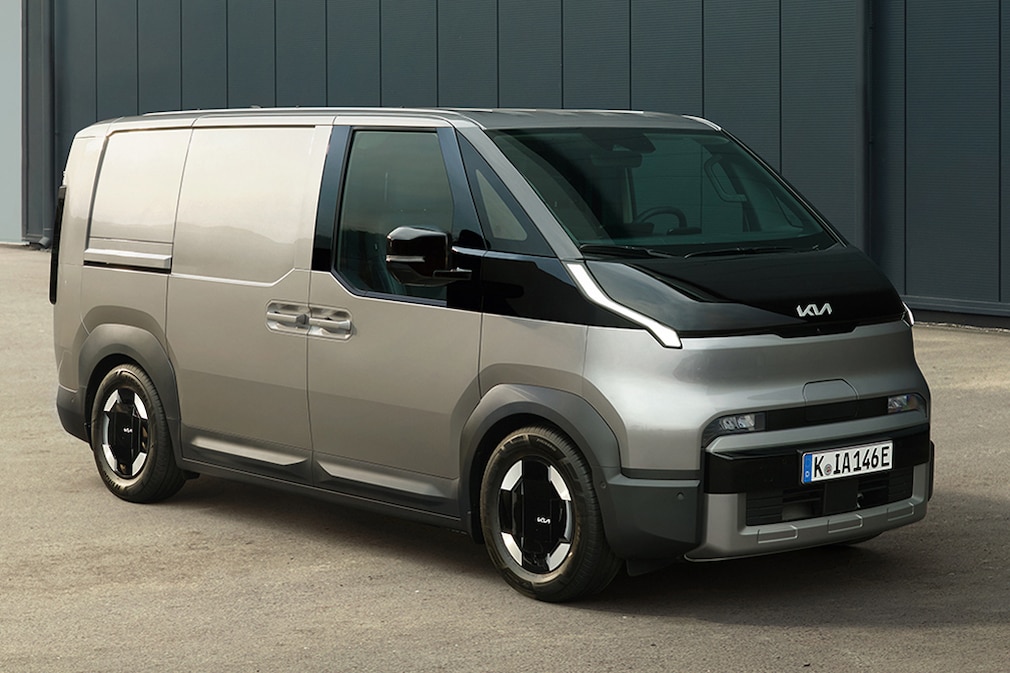 Kia PV5 Cargo in Grau, schräg von vorn auf Betriebsgelände.
