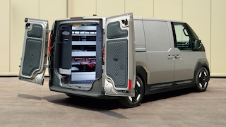 Kia PV5 Cargo mit Würth-Handwerkerausbau, schräg von hinten vor Halle.