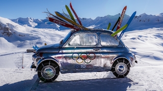 Fiat Nuova 500 im Skigebiet mit Skiern gestopft und den Olympischen Ringe auf der Tür