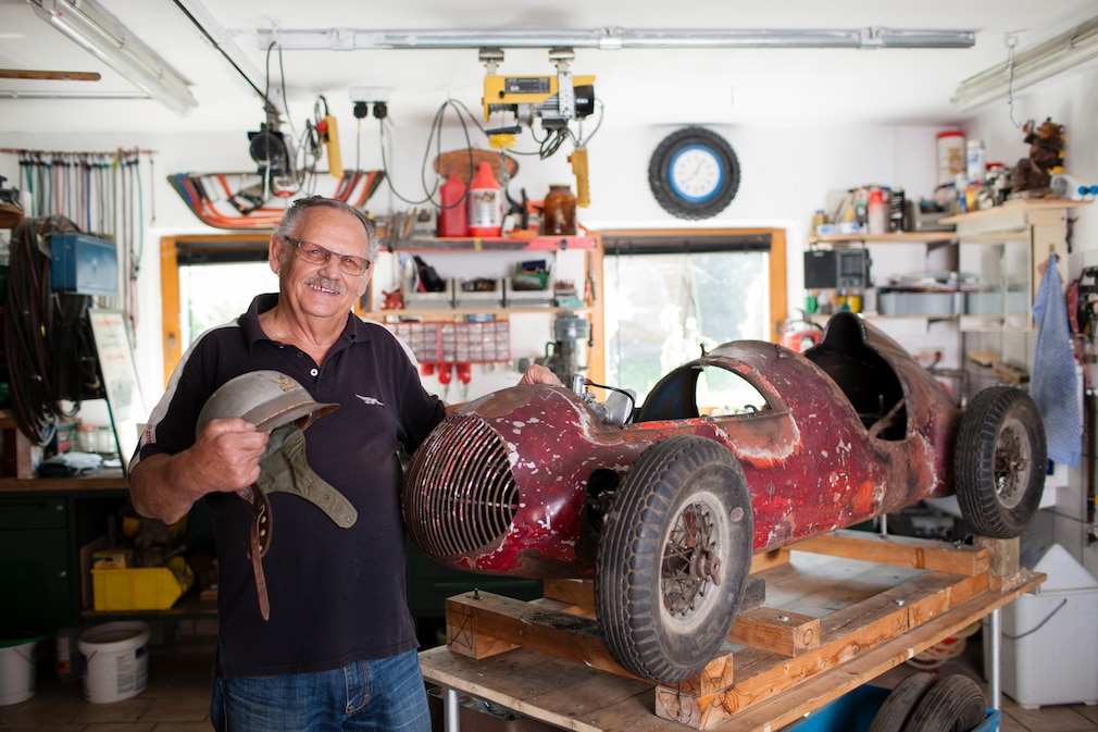 Schuhnagel mit 74 an seinem alten, patinierten Mini-Rennwagen