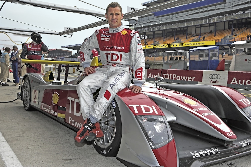 Tom Kristensen sitzt auf seinem Le-Mans-Rennwagen mit TDI-Schriftzug