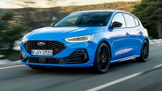 Blauer Ford Focus ST Edition fährt auf einer kurvigen Landstraße.