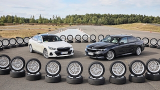Zwei BMW 5er stehen in einem Kreis aus Rädern, auf denen die Testkandidaten montiert sind
