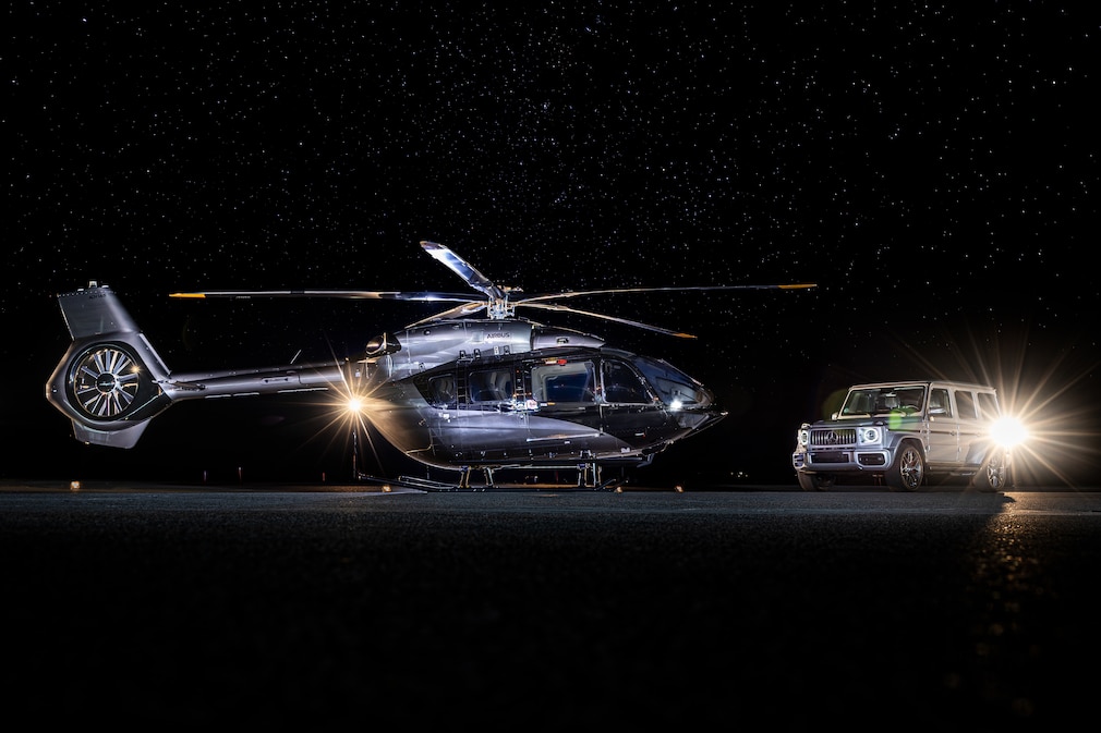 Airbus-Helikopter steht nachts neben einer Mercedes-G-Klasse auf dem Rollfeld.