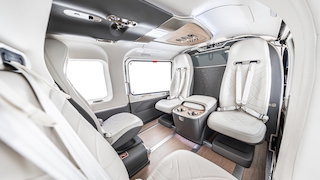 Innenraum eines Airbus-Helikopters mit Ledersitzen und Mittelkonsole.
