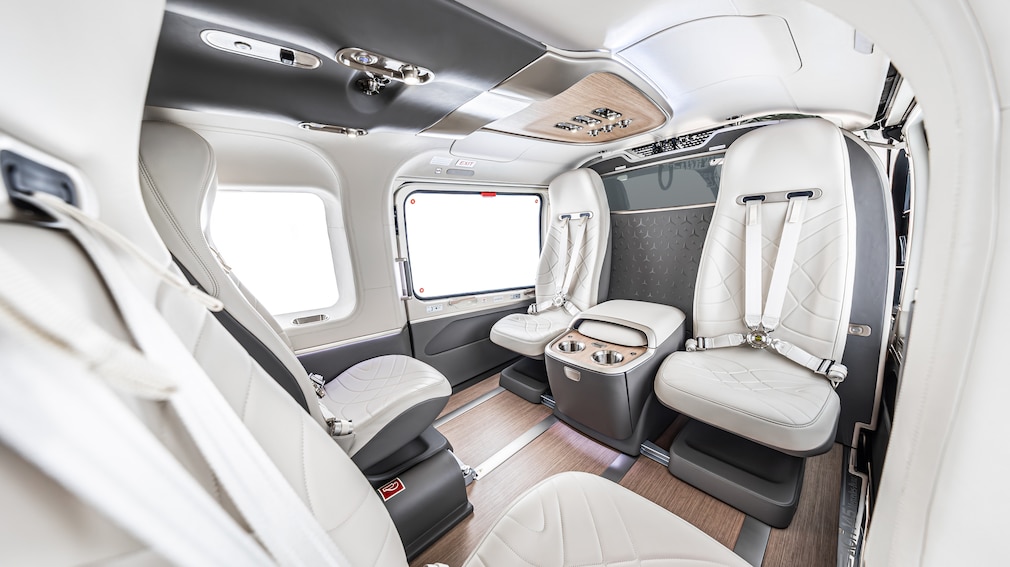 Innenraum eines Airbus-Helikopters mit Ledersitzen und Mittelkonsole.