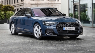 Audi A8 (Plug-in-Hybrid, erkennbar am E-Kennzeichen) in einer modernen Innenstadtumgebung.