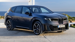 BMW iX3 50 xDrive vor modernem Haus mit Meerblick.