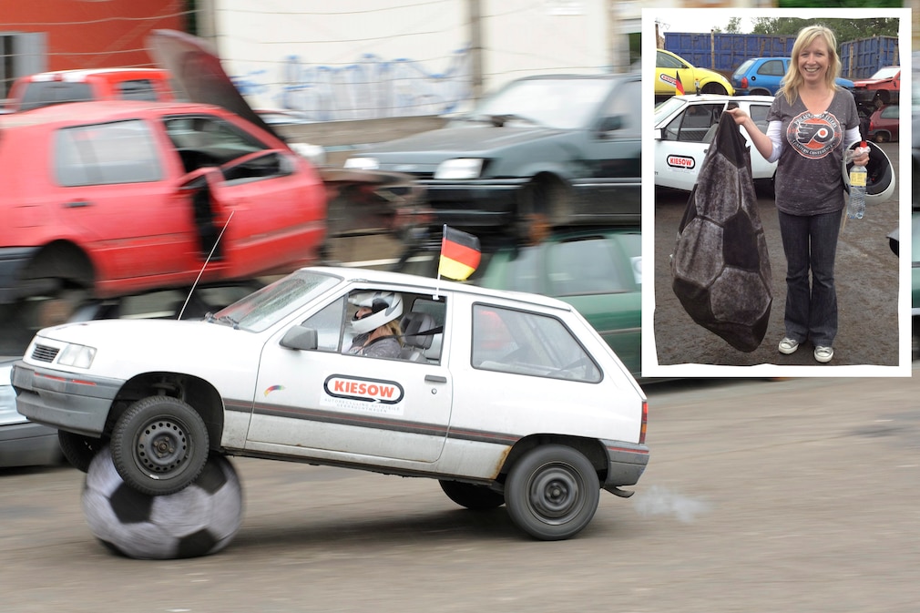 Opel Corsa A fährt bei Autoball über den Ball; dazu die AUTO BILD-REDAKTEURIN, DIE DEN KAPUTTEN BALL ZEIGT.