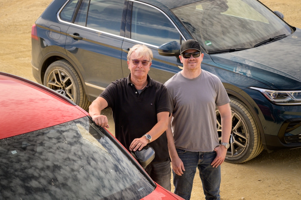 Die Reifentester Dierk Möller und Martin Westerhoff stehen zwischen zwei SUV, die auf dem Offroad-Kurs abgestellt sind