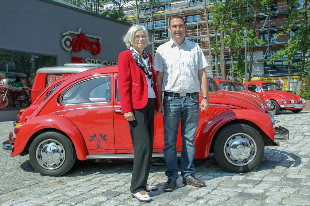 Gunhild Liljequist und Marco Strohmeier vor einem VW Käfer Sondermodell "Samtroter Sonderkäfer"