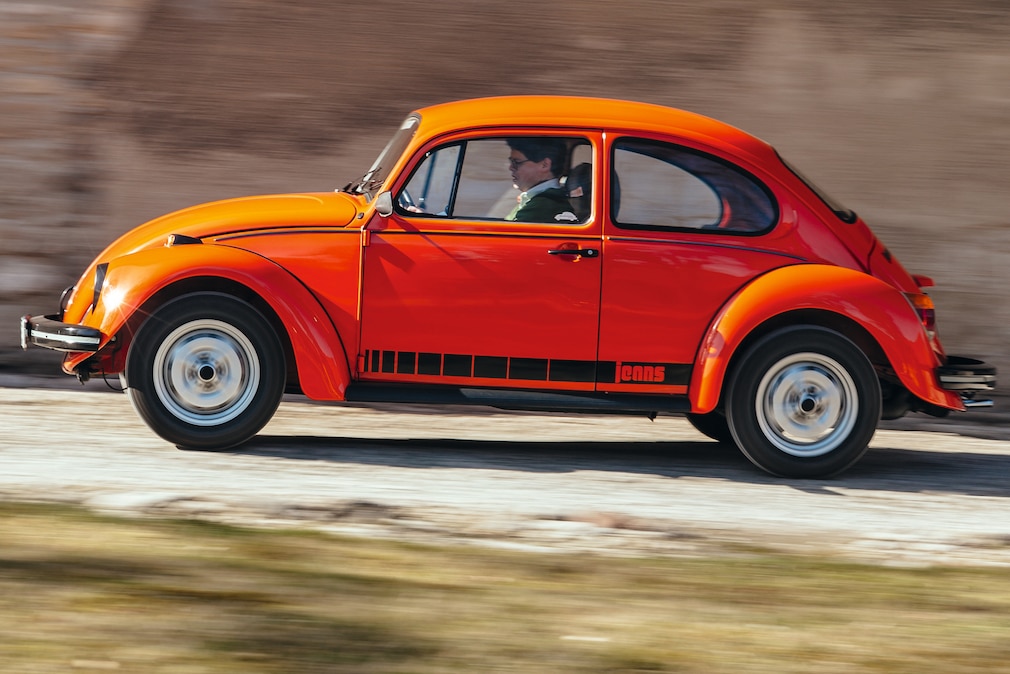 VW Jeans-Käfer fahrend von der Seite