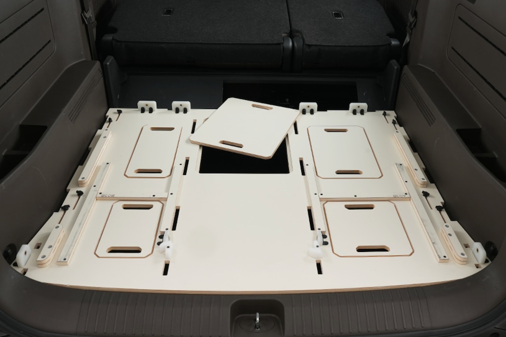 Blick in den Kofferraum des Kia PV5 Passenger mit dem Unterbau des Campingmoduls