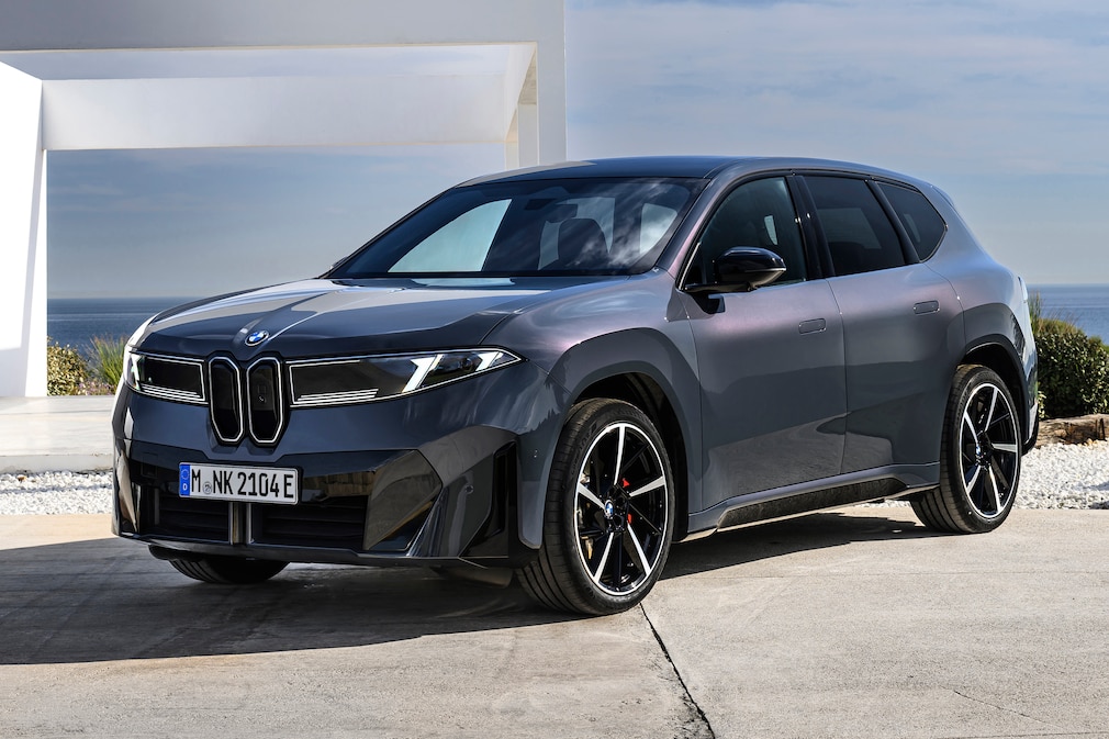 BMW iX3 parkt vor einem modernen Haus.