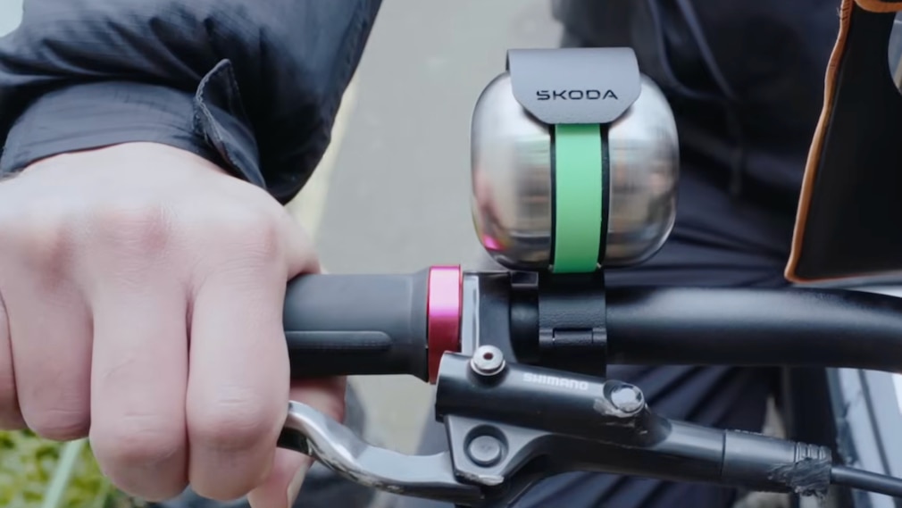 Detailaufnahme eines Fahrradlenkers mit Skoda-Klingel während der Fahrt.
