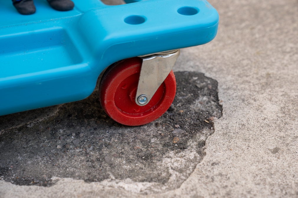 Rolle eines Werkstatt-Rollbretts auf extrem unebenem Boden