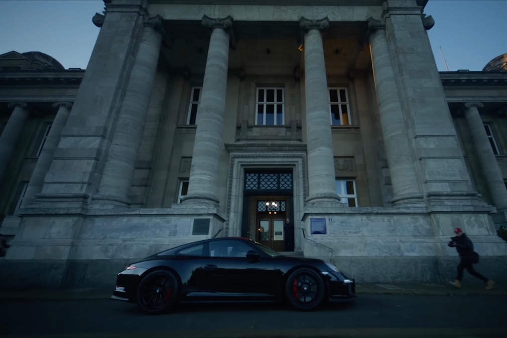 Porsche 911 fährt vor Gerichtsgebäude vor