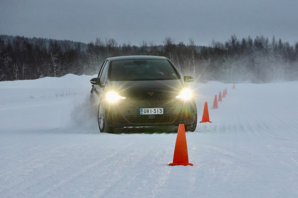 Der Testwagen Cupra Born durchfährt einen mit Leitkegeln abgesteckten Slalom auf schneebedeckter Fahrbahn