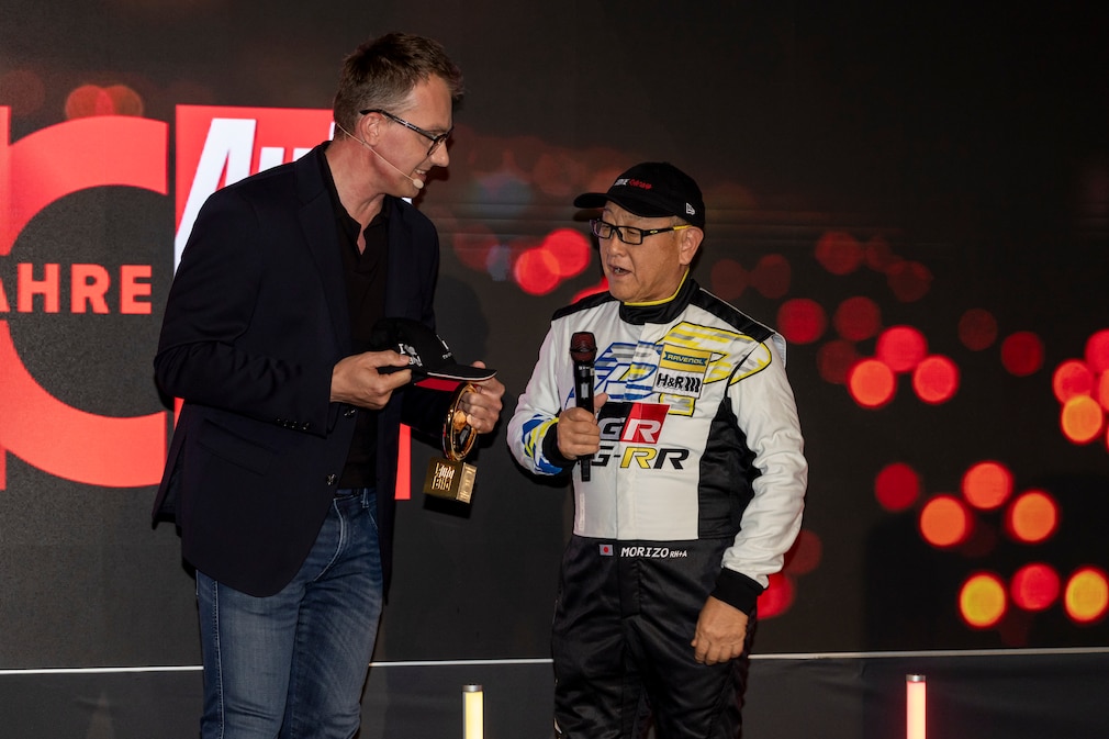 Robin Hornig überreicht Akio "Morizo" Toyoda das Goldene Ehrenlenkrad für sein Lebenswerk.