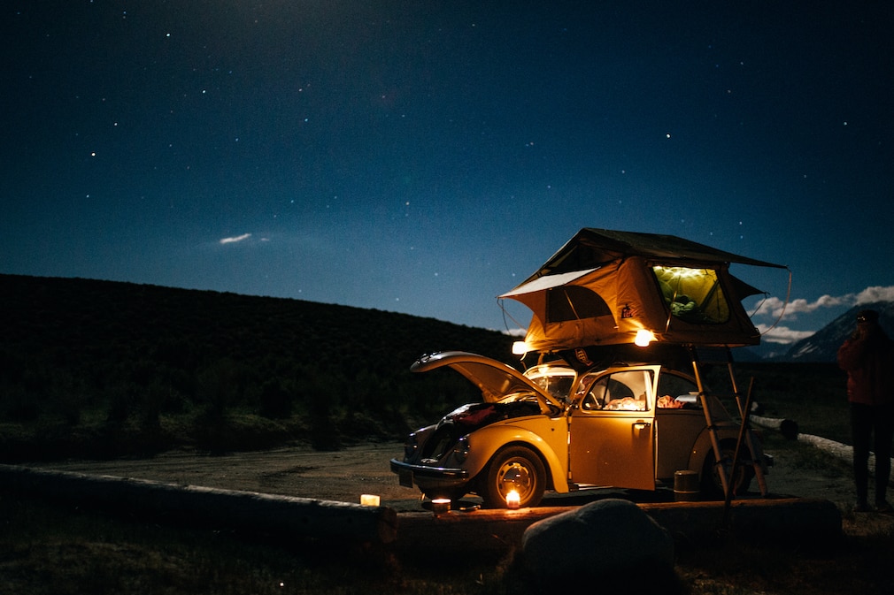 VW Käfer Última Edición mit Dachzelt bei Nacht