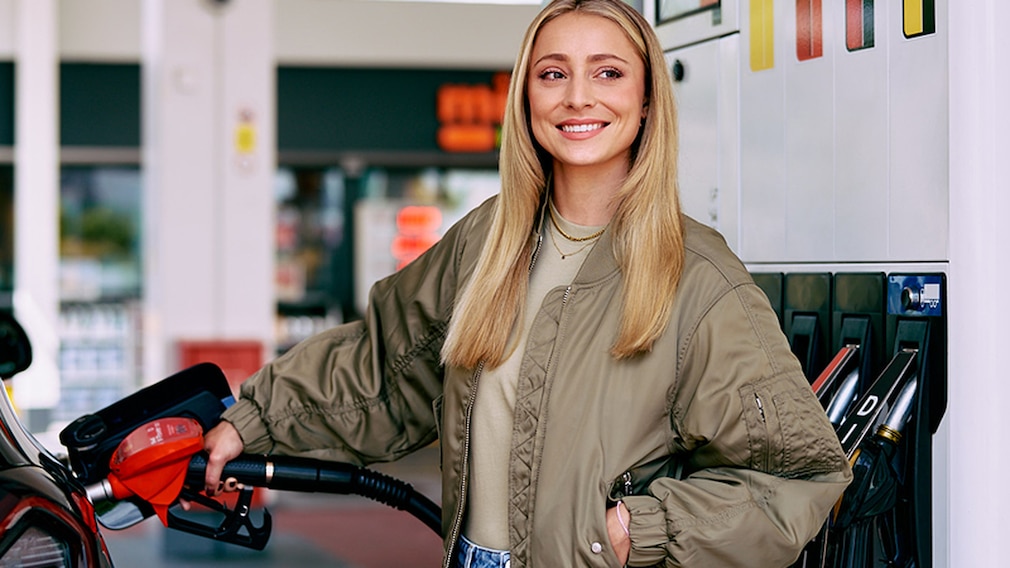 Frau steht am Auto