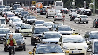Radfahrerin und Autos im Verkehr, Leipziger Straße, Berlin