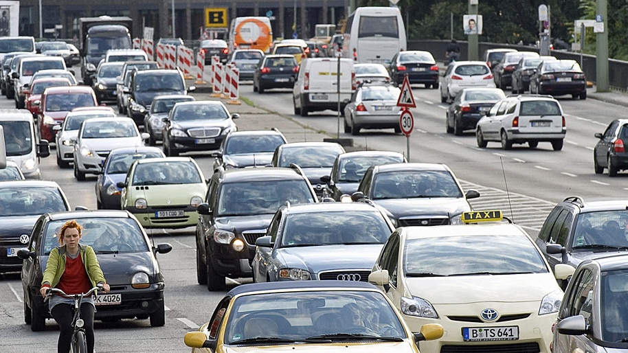 Radfahrerin und Autos im Verkehr, Leipziger Straße, Berlin