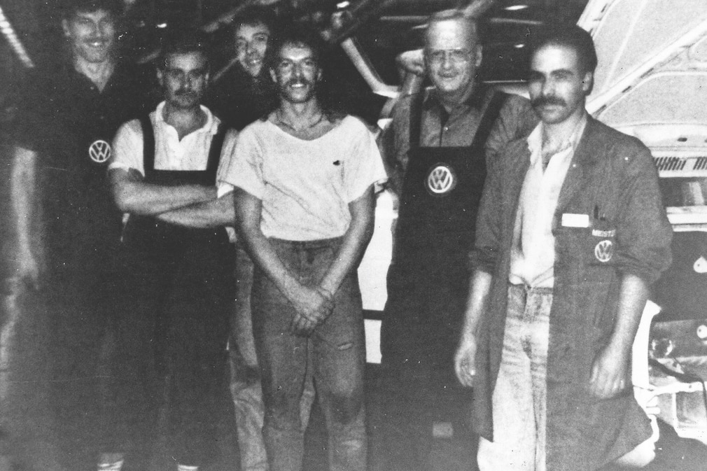 Carl H. Hahn mit Arbeitern am VW-Fließband
