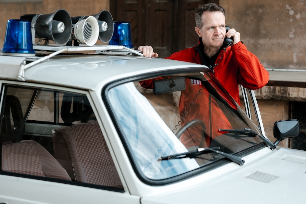 AUTO BILD-Redakteur mit Telefonhörer des Funkgeräts am Volkspolizei-Wartburg