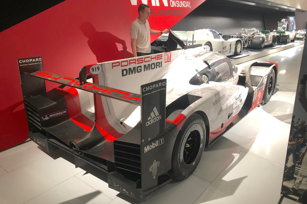 Porsche 919 Hybrid in der Ausstellung, schräg von hinten, mit Rennfahrer Marc Lieb