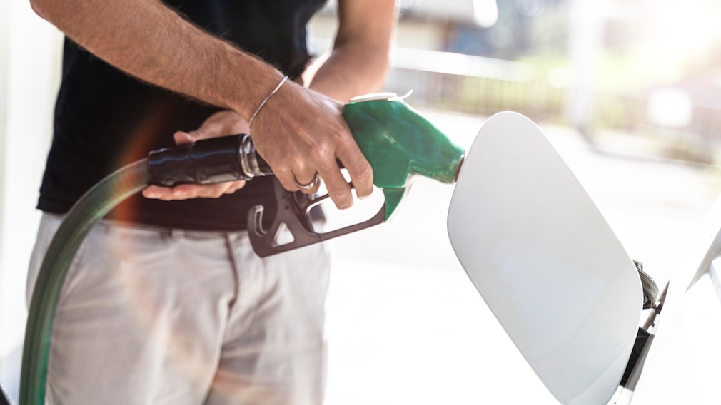Ein Mann Tankt sein Auto an einer Zapfsäule an einer Tankstelle - Symbolbild Tanken