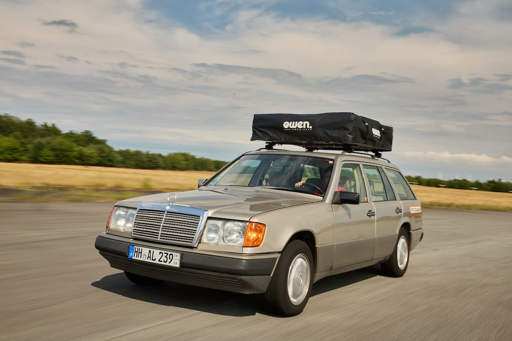 Goldener Mercedes S124 fährt mit eingefaltetem Dachzelt