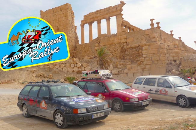zwei VW Passat 35i an einer Ausgrabungsstätte im arabischen Raum, dazu das Logo der Allgäu-Orient-Rallye
