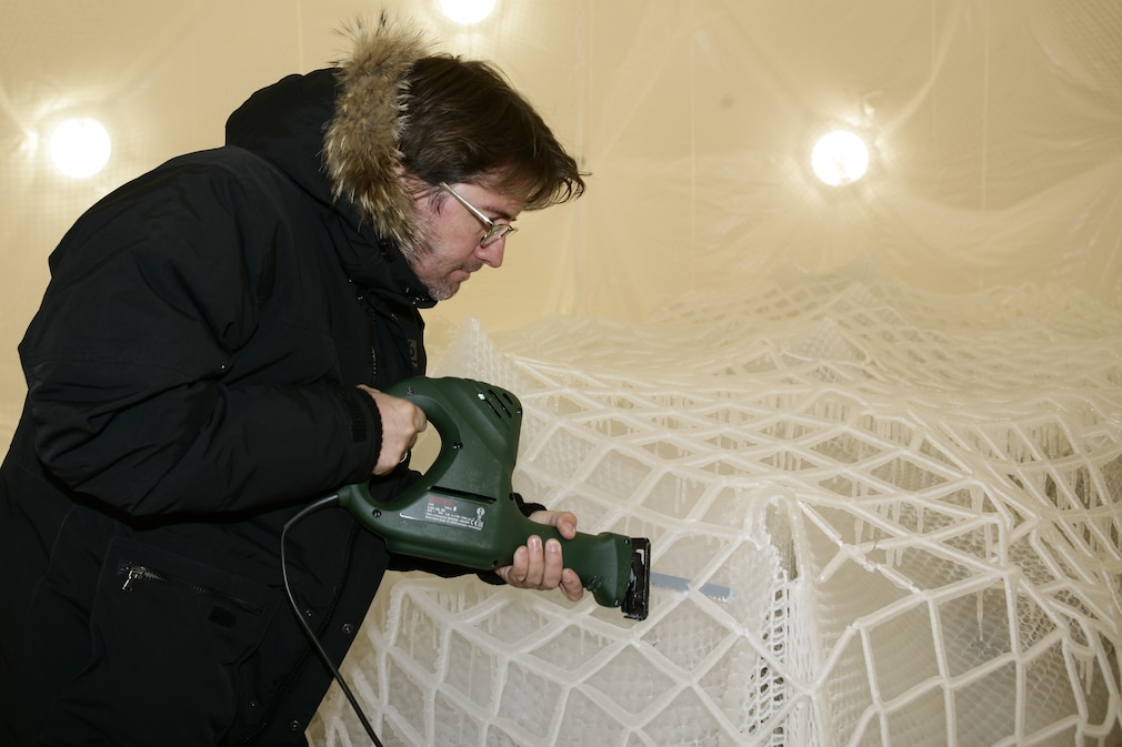 Ólafur Elíasson arbeitet mit einer elektrischen Säge an der Eisskulptur