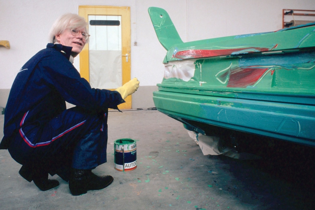 Andy Warhol am Heck des BMW Art Car BMW M1, während er das Auto bemalt