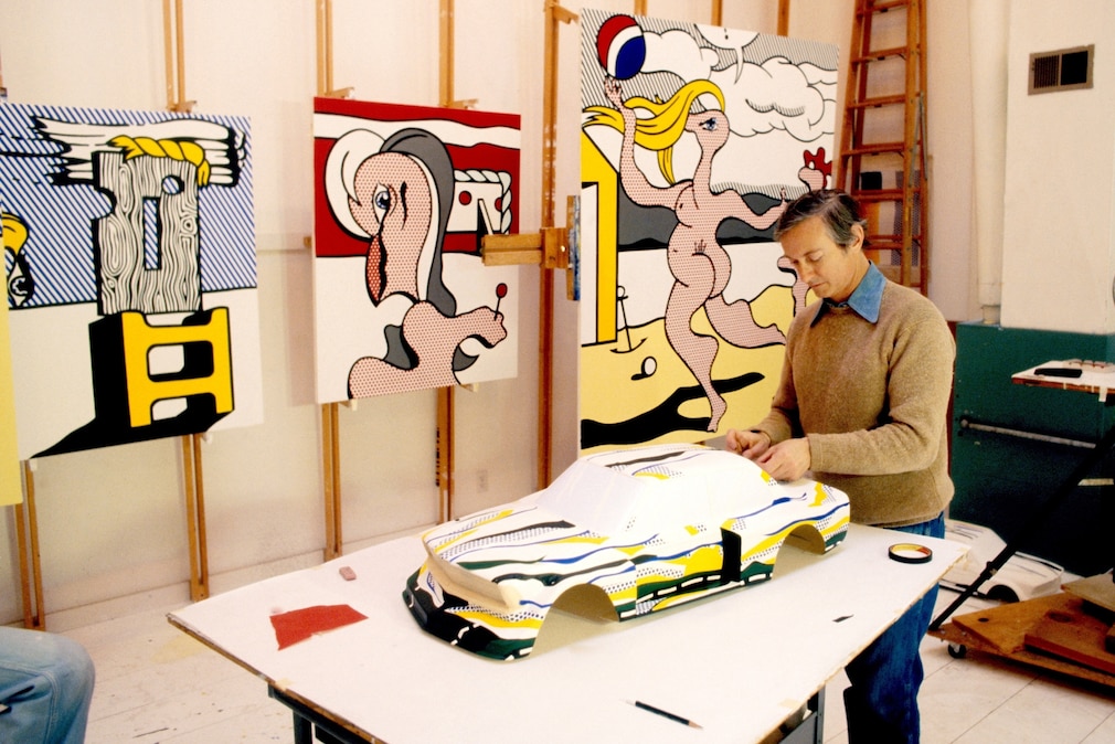 Roy Lichtenstein im Atelier mit Bildern, er arbeitet an der Maquette zum BMW Art Car BMW 320i turbo