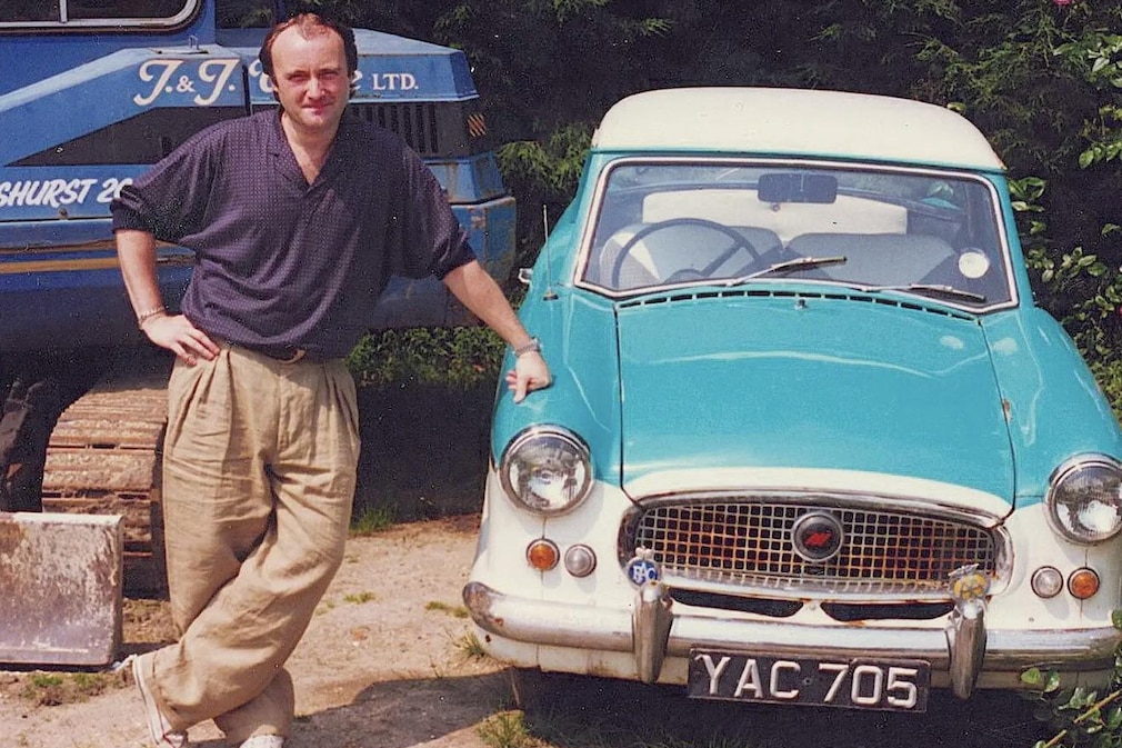 Phil Collins lehnt am unrestaurierten Austin Metropolitan