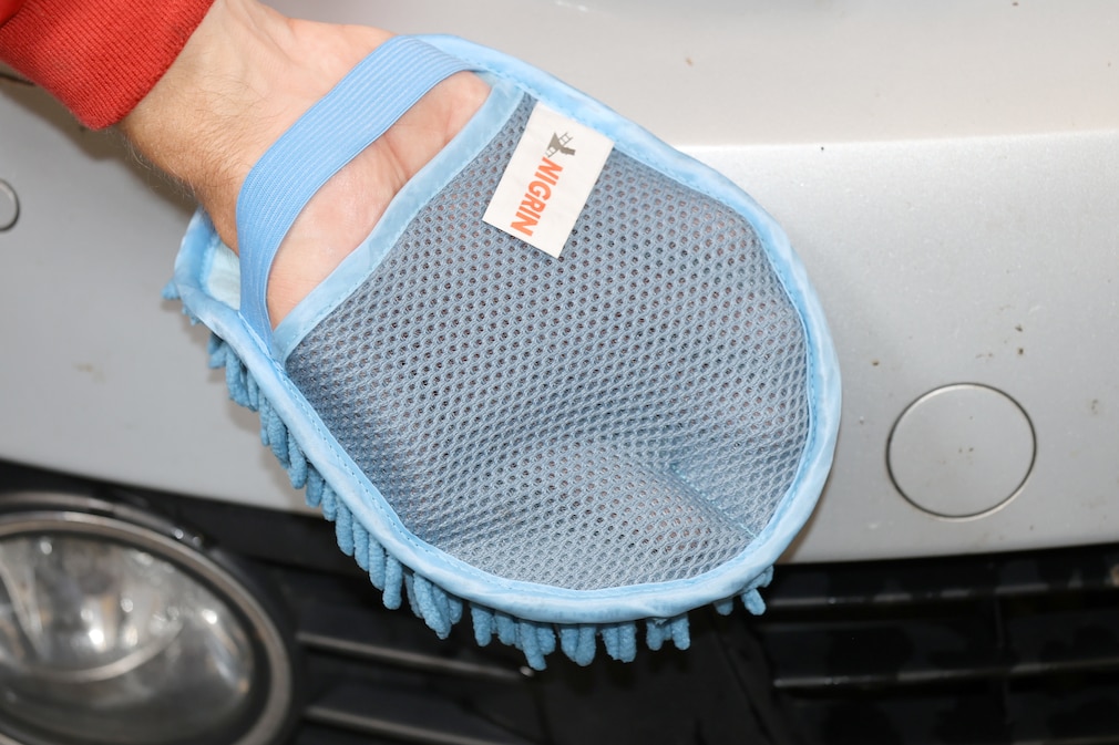 Redakteur gleitet mit Hand im Waschhandschuh über Motorhaube eines Golv VI.