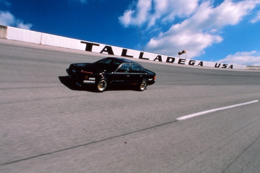 Rekordauto Audi 5000 CS turbo quattro fahrend in der Steilkurzve, dahinter Schriftzug "Talladega"