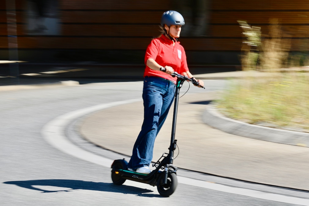 Person fährt auf einem E-Scooter im Kreisverkehr