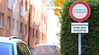 Ein Verbotsschild mit der Aufschrift "Ausgenommen Garagenbesitzer - Bei Nichtbeachtung Anzeige wegen Besitzstörung" im Bereich einer Wohnsiedlung in Salzburg/Österreich
