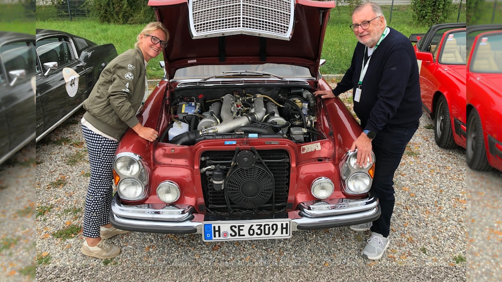 Britta Mattern und Manfred Hundold an der offenen Motorhaube seines Mercedes 300 SEL 6.3 (W 109)