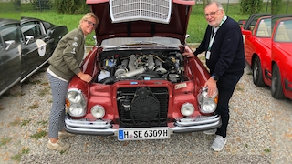 Britta Mattern und Manfred Hundold an der offenen Motorhaube seines Mercedes 300 SEL 6.3 (W 109)