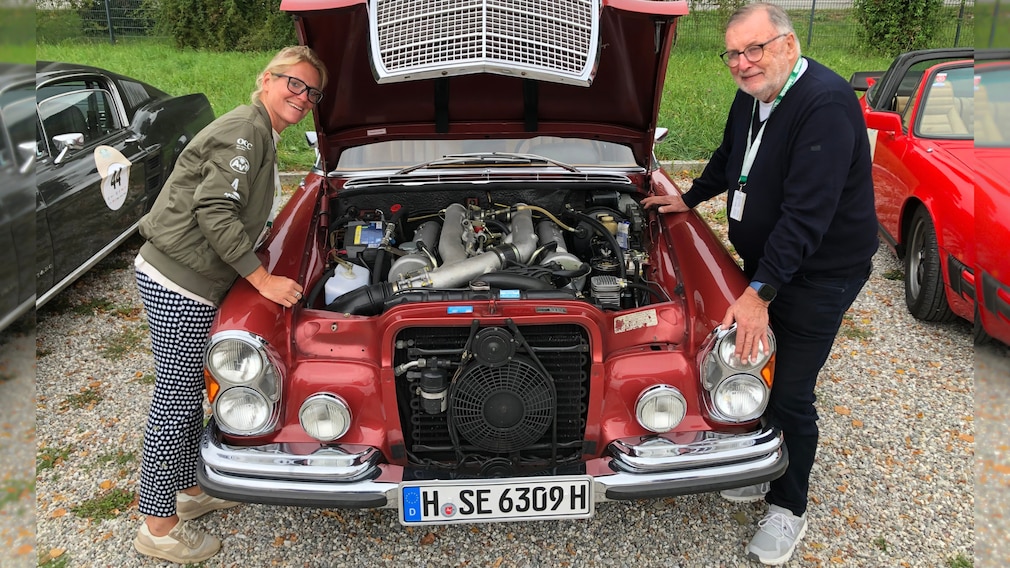 Britta Mattern und Manfred Hundold an der offenen Motorhaube seines Mercedes 300 SEL 6.3 (W 109)